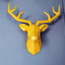 Yellow geometric deer head wall mount with faceted polygonal design on blue background.