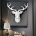 White geometric deer head wall sculpture with antlers mounted on gray framed background.