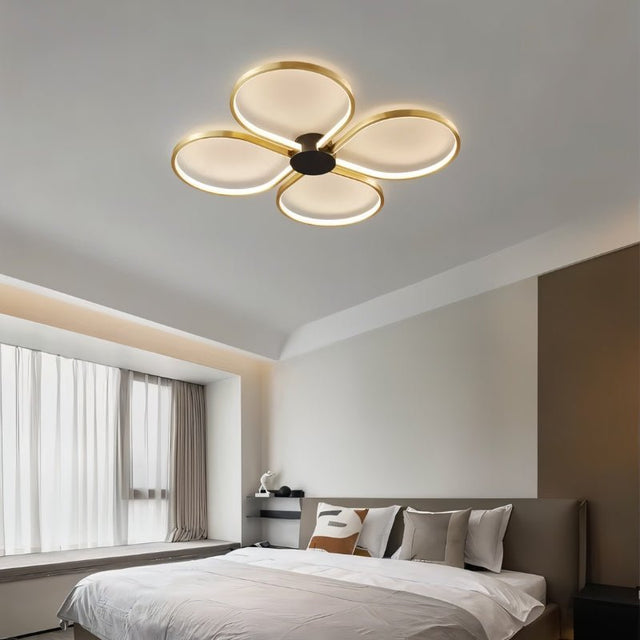 "Modern ceiling light with four circular LED rings in a clover design, providing bright illumination in a contemporary bedroom."