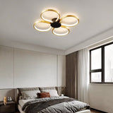 "Modern ceiling light with four circular LED rings in a clover design, illuminating a contemporary bedroom."