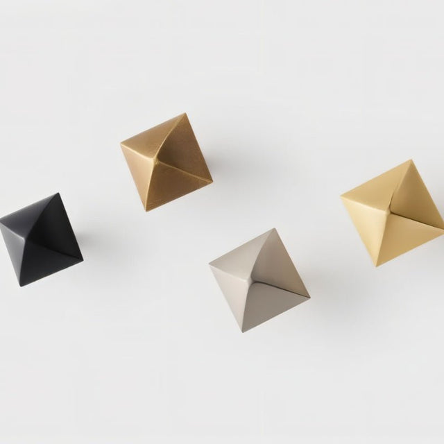"Group of pyramid-shaped brass knobs in various finishes on a white background."