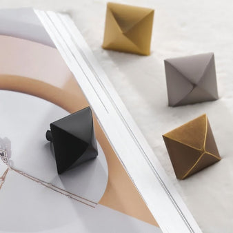 "Pyramid-shaped brass knobs in various finishes on a magazine."