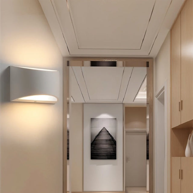 "Modern curved rectangular gypsum wall lamp providing ambient up and down lighting in a contemporary hallway."