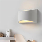 "Modern minimalist curved rectangular gypsum wall lamp casting soft light up and down."