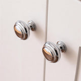 "Polished chrome brass knobs on a cabinet, showcasing an elegant, timeless design for luxury interiors."