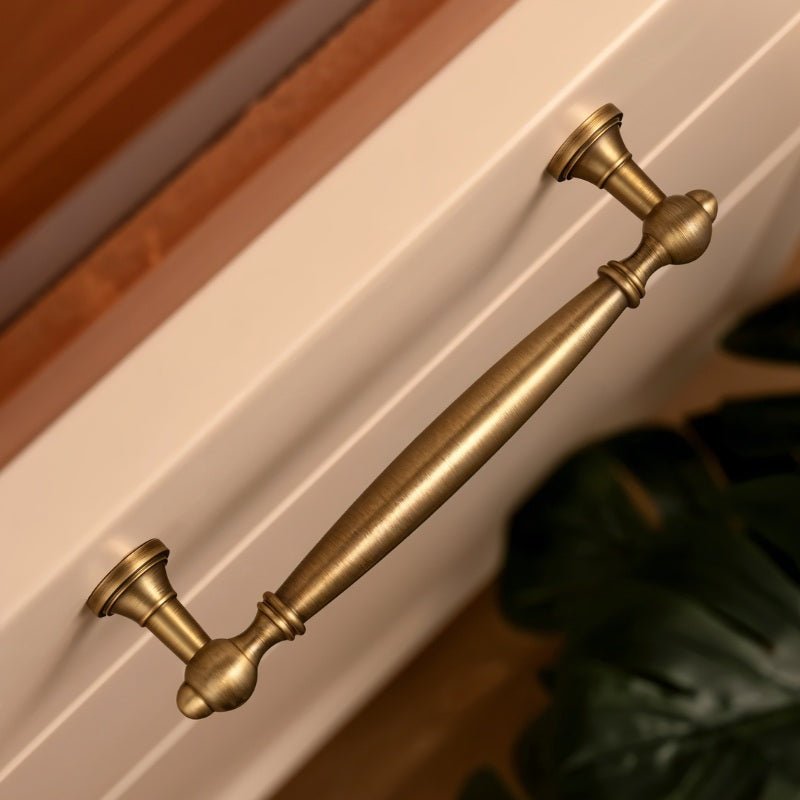 "Antique brass pull bar on a cabinet, showcasing an elegant, timeless design for luxury interiors."