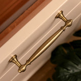"Antique brass pull bar on a cabinet, showcasing an elegant, timeless design for luxury interiors."