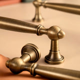 "Close-up of antique brass pull bars with intricate detailing, showcasing an elegant, timeless design."