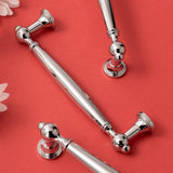"Polished chrome brass pull bars with an elegant, timeless design on a red background, ideal for luxury interiors."