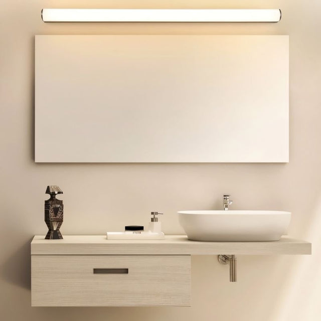 "Illuminated modern wall lamp with a white diffuser above a rectangular bathroom mirror and a contemporary vanity setup."