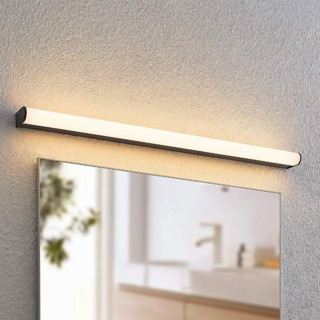 "Modern black wall lamp illuminating a bathroom vanity mirror, mounted on a textured wall."