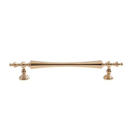 "Brass pull bar handle with a tapered spindle design and intricate finials isolated on a white background."