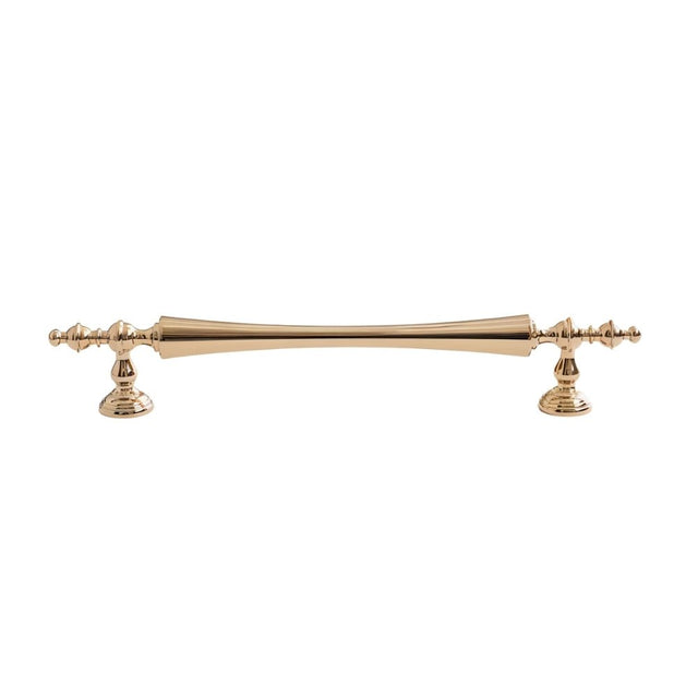 "Brass pull bar handle with a tapered spindle design and intricate finials isolated on a white background."