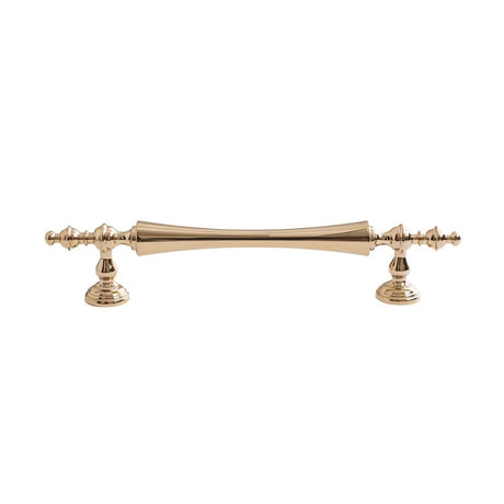 "Brass pull bar handle with a tapered spindle design and intricate finials on a white background."