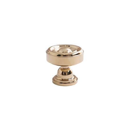 "Brass cabinet knob with a tapered spindle design and intricate finials isolated on a white background."