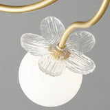 "Close-up of a ceiling light showing a frosted glass globe and a decorative glass petal detail on a curved metal arm."