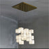 Multi-tiered frosted glass cube pendant chandelier with brass canopy hanging in a modern interior space.