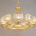 Gold chandelier with crystal shades and multiple light fixtures suspended against a neutral background.
