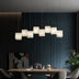 Modern alabaster pendant light with frosted glass shades suspended above a dining table in contemporary interior.