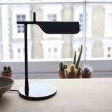 "Sleek black table lamp with a minimalist metal design, featuring an adjustable shade for modern workspace lighting"