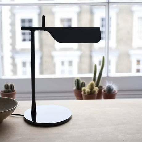 "Sleek black table lamp with a minimalist metal design, featuring an adjustable shade for modern workspace lighting"