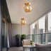 Brass globe ceiling light fixture with warm amber glass shade in modern balcony setting.