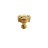 "Front view of a brass knob with a concentric ring design and ridged surface, suitable for modern and transitional interiors."