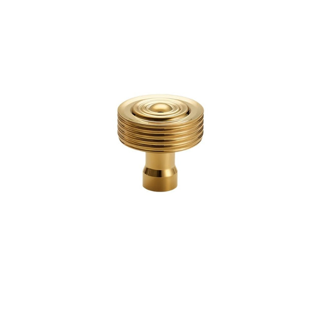"Front view of a brass knob with a concentric ring design and ridged surface, suitable for modern and transitional interiors."