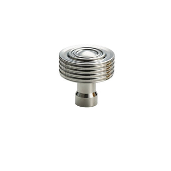 "A nickel-finished brass knob featuring a concentric ring design and ridged surface for enhanced grip and visual appeal."