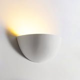 "Gypsum and aluminum half-sphere wall light fixture casting a soft upward light, ideal for contemporary interiors like living rooms and hallways."