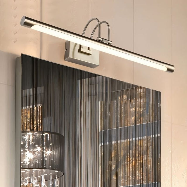 "A silver wall lamp with a linear LED bar mounted above a modern bathroom mirror with a dark abstract pattern."