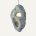 Gray pendant light with organic cutout design and warm brass interior accents, suspended against white background.
