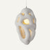 White pendant light with organic cutout design and warm interior glow against neutral background.