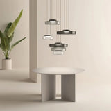 "Multiple glass disc pendant lights above a dining table."