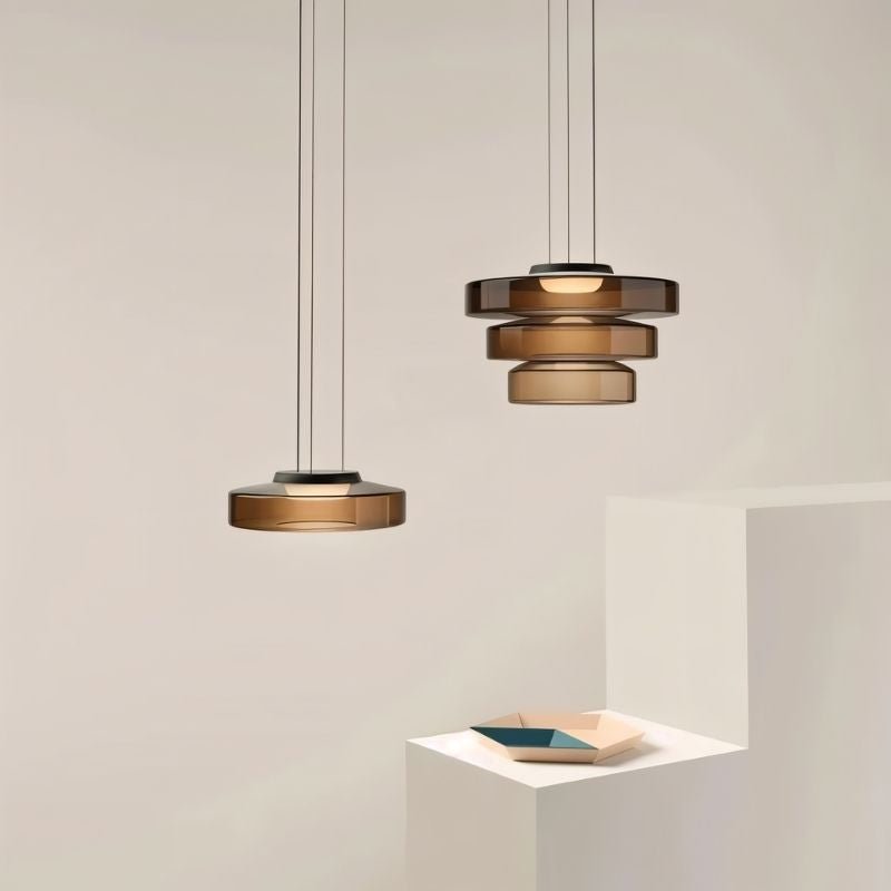 "A set of glass disc pendant lights in different sizes."
