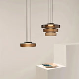 "A set of glass disc pendant lights in different sizes."