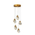 Multi-pendant ceiling light with five faceted crystal shades and brushed brass fittings on white background.