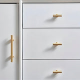 "Gold brass knobs and pull bars with cylindrical design, mounted on a white dresser with drawers and a cabinet door."