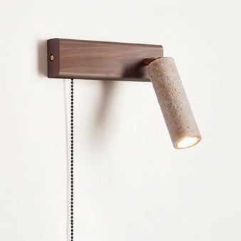 "Lindr wall-mounted bedside lamp with a cylindrical light fixture made from walnut wood and travertine, perfect for illuminating a cozy corner."