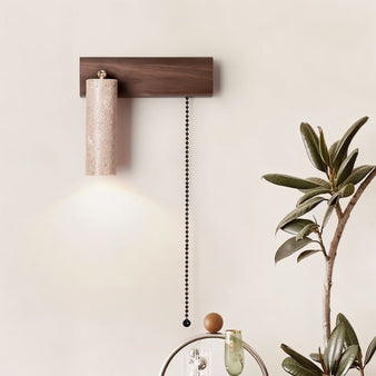 "Lindr wall lamp installed in the living room, featuring a sleek cylindrical design with natural travertine and walnut materials, offering a warm light."