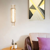 "Modern crystal wall lamp with a vertical, cylindrical design, mounted on a wall in a contemporary living room."