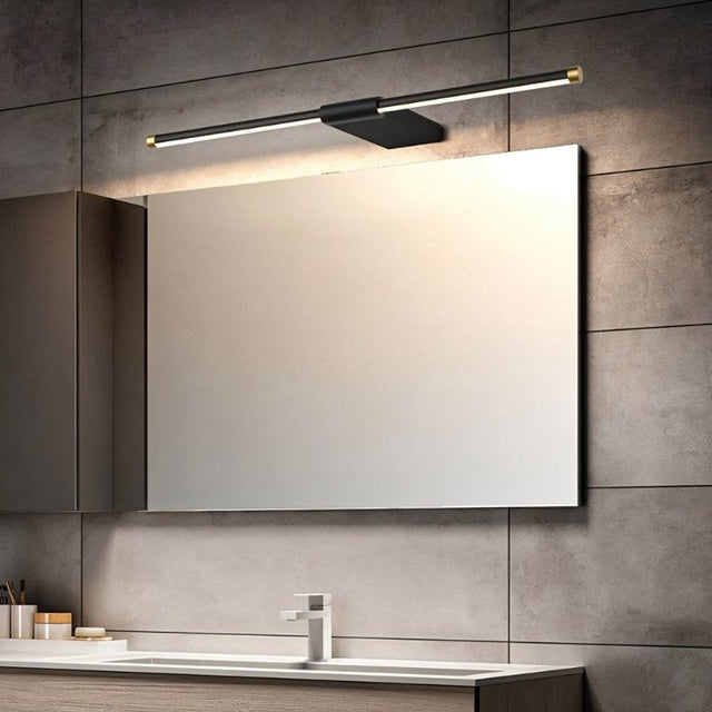"Contemporary bathroom featuring a Lisorva wall lamp in black with brass accents, providing focused light above a large vanity mirror."