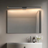 "Sleek Lisorva wall lamp in black metal and PC with brass accents, providing even illumination above a modern bathroom vanity mirror."