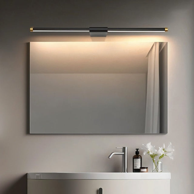 "Sleek Lisorva wall lamp in black metal and PC with brass accents, providing even illumination above a modern bathroom vanity mirror."