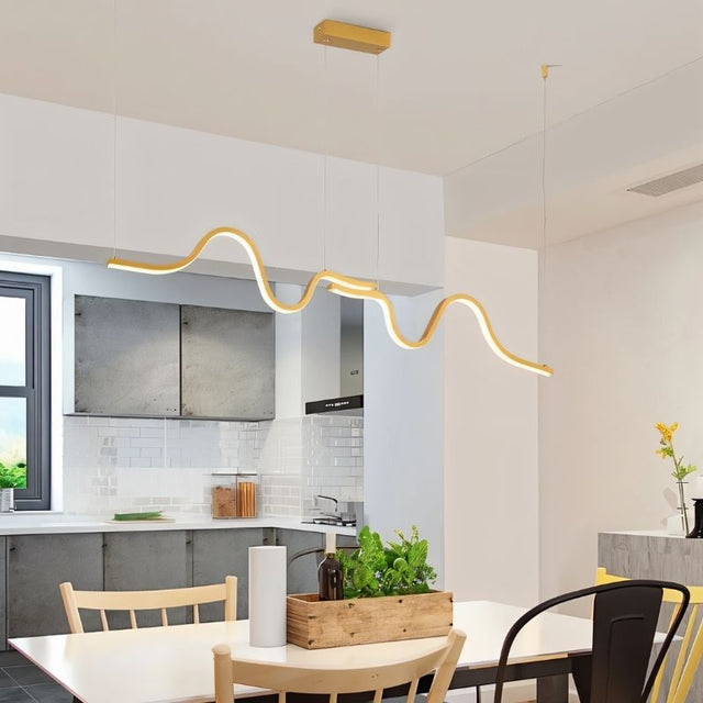 "A gold wave-like pendant light with a sculptural design, suspended above a dining table in a modern dining room, providing diffused illumination."