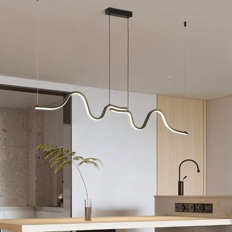 "A wave-like pendant light with a sculptural design, suspended above a kitchen island, providing diffused and modern illumination."