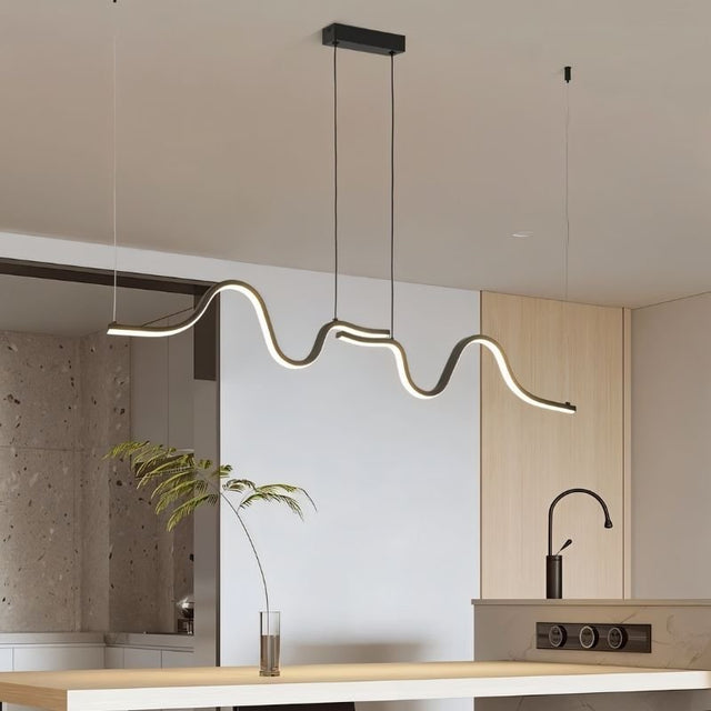 "A wave-like pendant light with a sculptural design, suspended above a kitchen island, providing diffused and modern illumination."