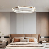 "An asymmetric dual-ring LED chandelier with iron and acrylic in a modern bedroom."