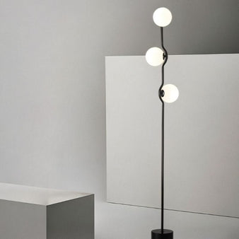 "modern minimalist floor lamp with curved iron frame and frosted glass globes"