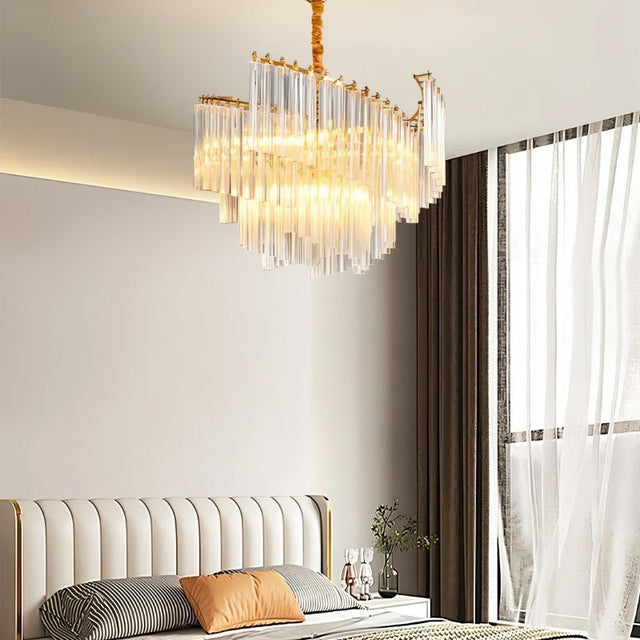 "A modern chandelier with tiered crystal rods, illuminating a bedroom with a soft, warm glow."
